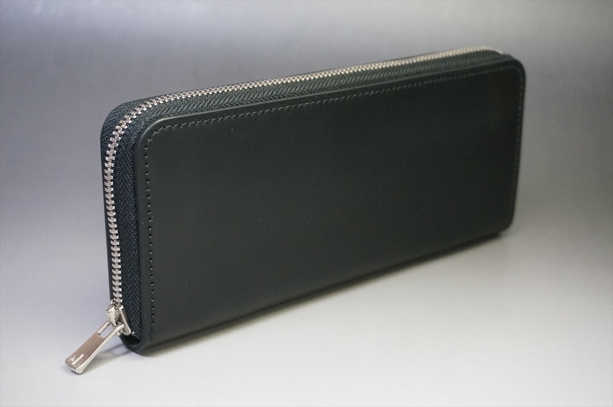 Black leather zip-around wallet with a silver zipper on a light gray surface.