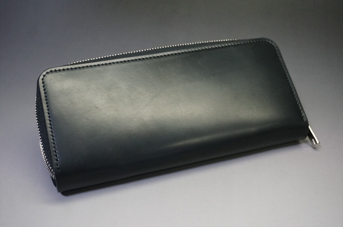Black leather zippered wallet on a gray background