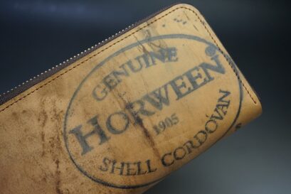 Close-up of a tan leather wallet with a circular stamp reading 'Genuine Horween Shell Cordovan' and '1905'.