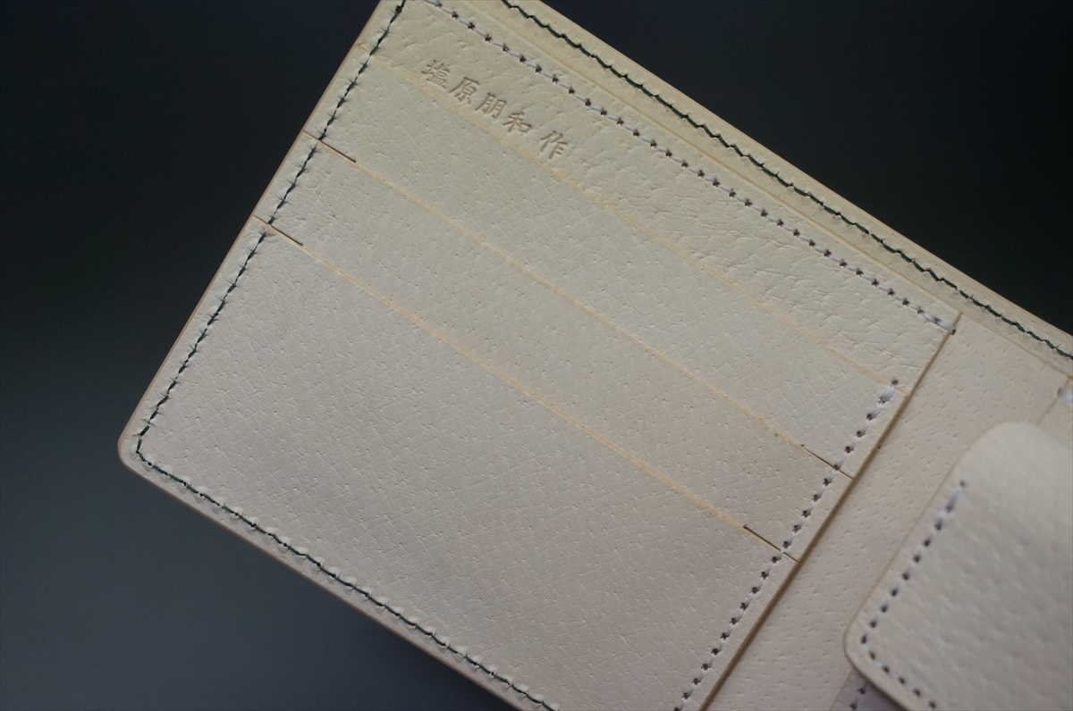 Beige leather wallet interior with three card slots and stitched edges.