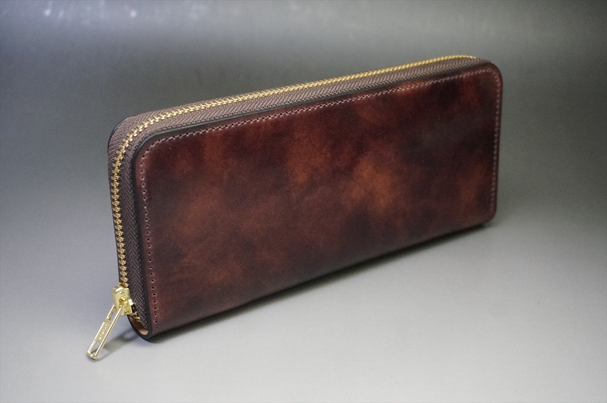 Brown leather zip-around wallet with a gold-tone zipper along the top edge.